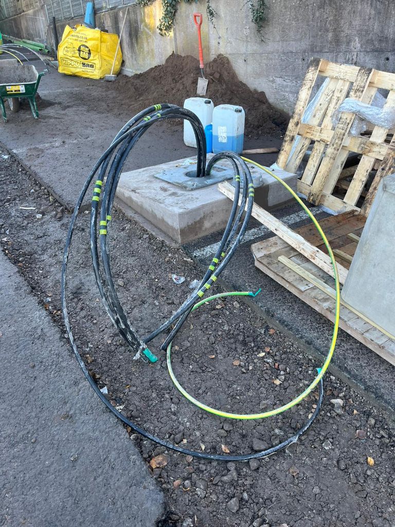 High-voltage DNO cables coiled on the ground awaiting installation — Coseley site