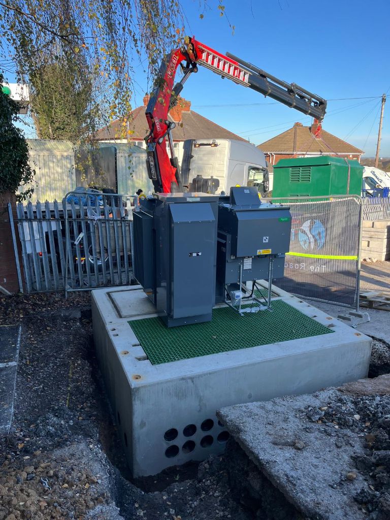 Crane lifting the transformer unit onto its concrete plinth during civil works at the Coseley, Dudley EV charging hub